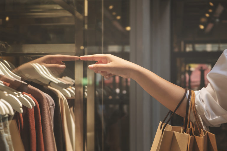 Hand of woman holding paper bags enjoy with shopping in the mall